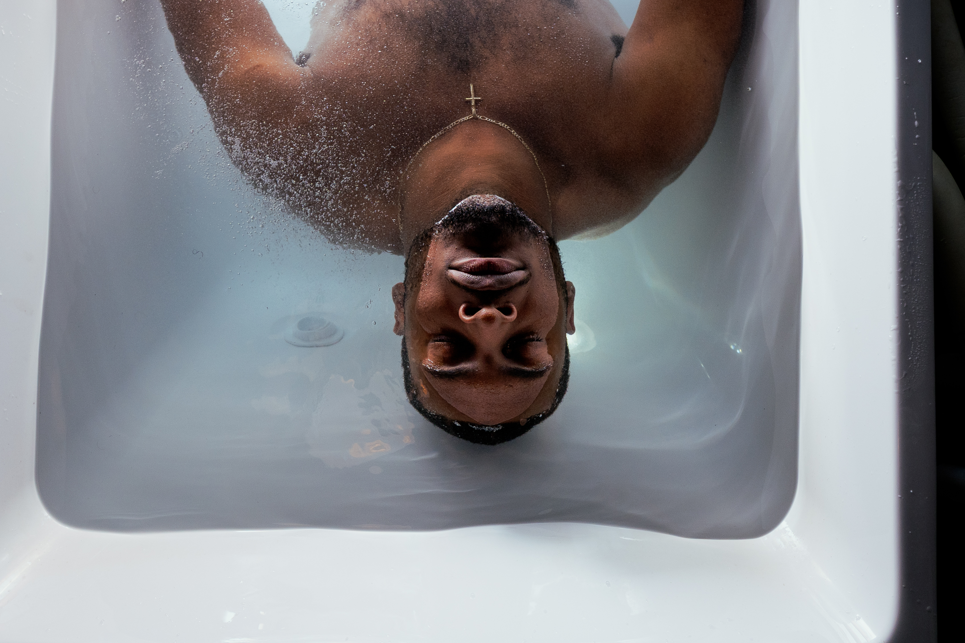 Close-up overhead shot of person in cold plunge bath with water droplets at Revibe