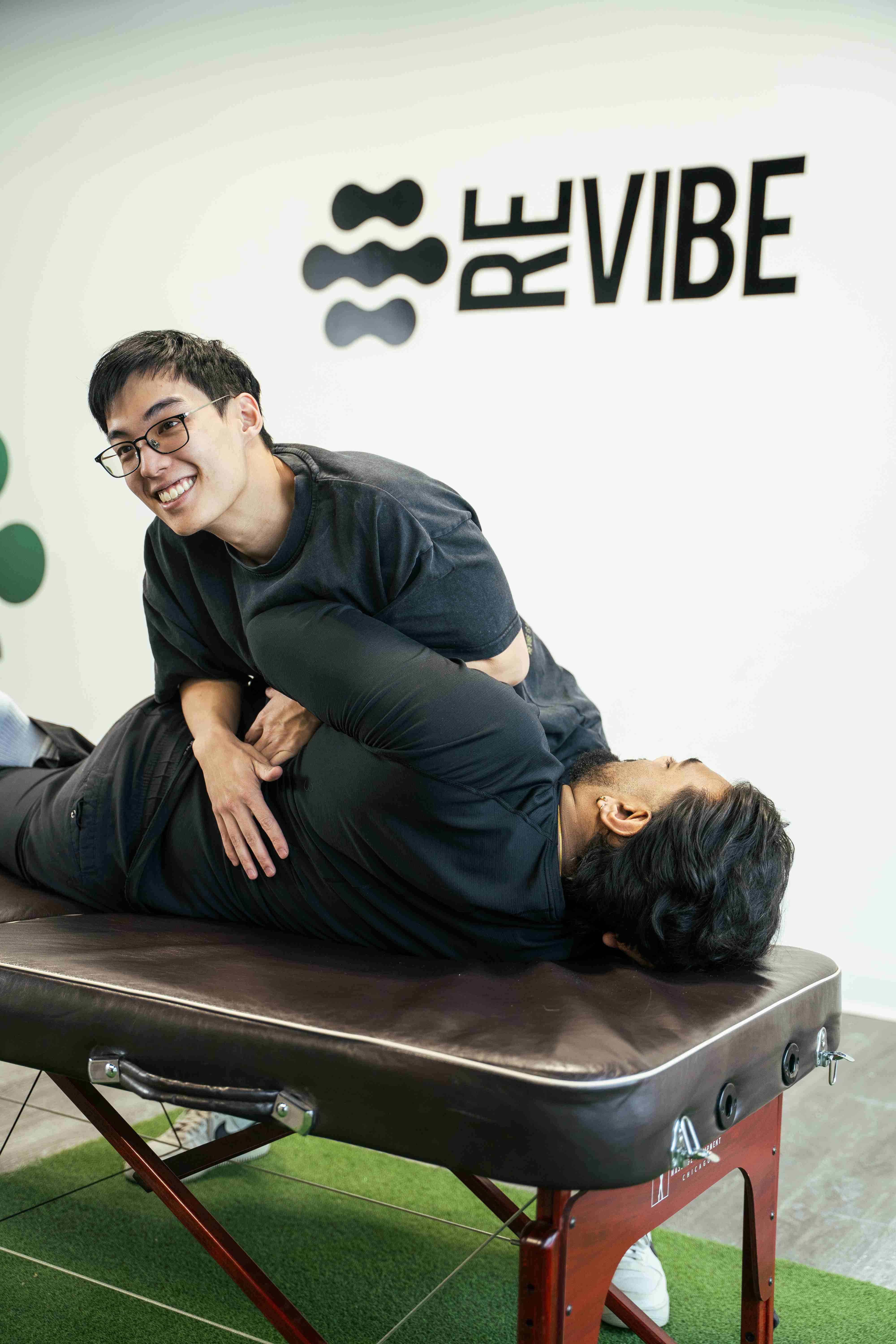 Physiotherapist performing a manual spinal mobilization on a patient lying on a treatment table.