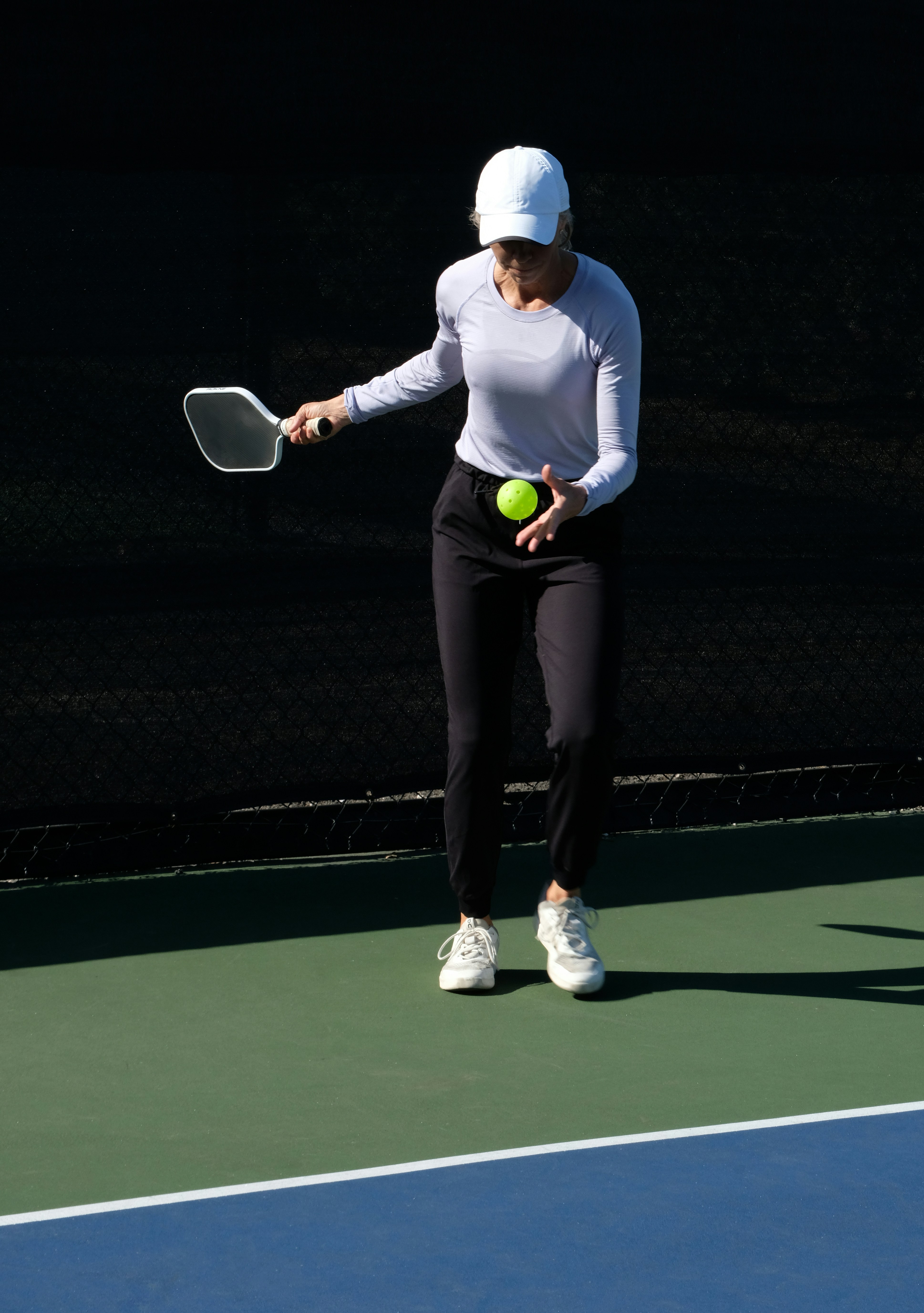Woman playing pickleball on an outdoor court