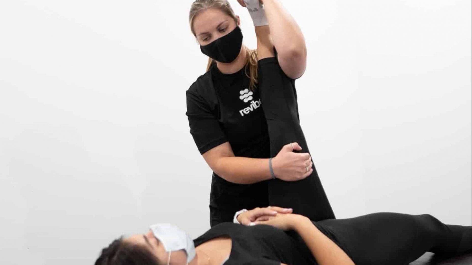 Registered physiotherapist performing stretches on customer.